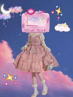 a girl in a pink dress is holding up a pink toy computer with stars and moon on it