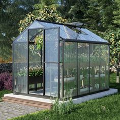 a small greenhouse in the middle of some grass