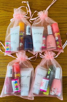 four bags filled with different types of beauty products on top of a wooden table next to each other