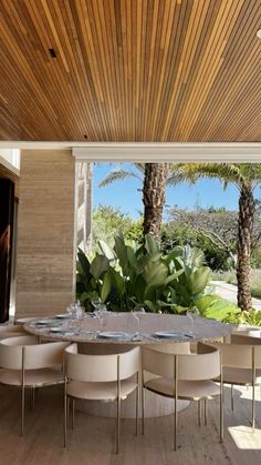 a dining room table and chairs with palm trees in the backgroung area