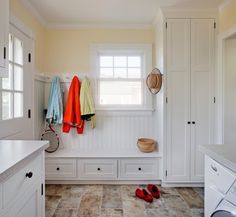 a washer and dryer in a white laundry room with towels hanging on the wall