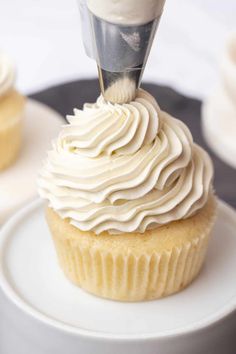 a cupcake being frosted with white icing