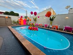 an empty swimming pool with chairs and balloons floating in the air on top of it