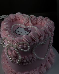 a pink hello kitty cake with pearls on top