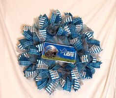 the detroit lions football helmet wreath is made out of blue and silver mesh ribbon with a white background