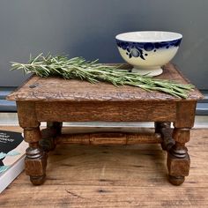 a wooden table topped with a bowl and two books