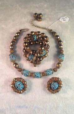 "This is a beautiful and stunning Hobé parure consisting of a necklace, earrings and wrap bracelet circa 1950s. All pieces are made from faceted gold glass beads, amber colored artglass beads covered with specks of turquoise glass, as well as round tangerine/orange rondelles and filigree caps throughout - a gorgeous combintaion of color and detail! The necklace measures 12\" with a 3\" extender and the beads are strung on fine chain. The bracelet is also in good condition, apart from one small d Turquoise Czech Glass Jewelry For Party, Party Jewelry In Turquoise Czech Glass, Turquoise Czech Glass Party Jewelry, Costume Jewelry With Czech Glass For Party, Czech Glass Costume Jewelry For Parties, Party Costume Jewelry With Czech Glass, Turquoise Czech Glass Jewelry With Spacer Beads, Turquoise Czech Glass Round Beads Jewelry, Turquoise Czech Glass Bead Jewelry