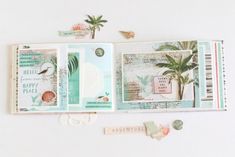 an open scrapbook with various papers and stickers on it, including palm trees