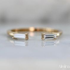 an image of two gold rings with white stones on top and one in the middle