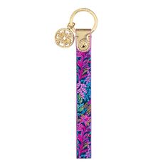 a keychain with a flower pattern on it and a gold plated charm