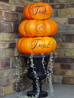 three pumpkins stacked on top of each other with the words trick or treat written on them