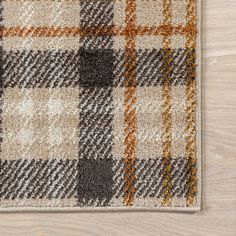 an area rug on the floor that is made out of wood and has different colored plaid patterns