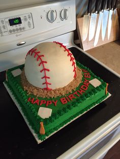 a baseball themed birthday cake sitting on top of a stove