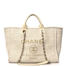 This is an authentic CHANEL Lurex Boucle Medium Deauville Tote in White. This lovely woven tote is crafted of mixed fibers and lurex in ivory with the iconic Chanel logo in gold. The bag features  leather top handles, grosgrain threaded gold chain shoulder strap, grosgrain canvas trim, and an open top.  The beige fabric interior features zipper and patch pockets Chanel Logo, Chanel Paris, Beige Fabric, Open Top, Leather Top, Gold Chain, Patch Pocket, Gold Chains, Luxury Bags