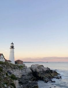 a light house sitting on top of a cliff next to the ocean