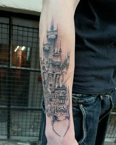 a man with a castle tattoo on his arm