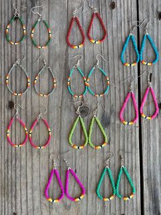 several pairs of earrings are displayed on a wooden surface