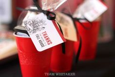 two red cups are wrapped in clear plastic and tied with black ribbon the cup has a tag that says thanks