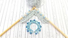 two crocheted knitting needles and a ball of yarn