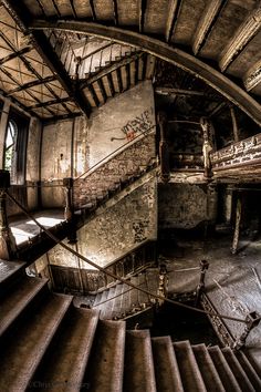 an abandoned building with stairs and graffiti on the walls