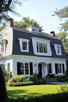 a large white house with black shutters on the front and windows in the back