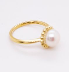 This lovely cultured pearl ring is the perfect gift for a loved one or a great self purchase. The nice size pearl has a gold beading design that is very simple but elegant. The pearl is the most desirable color with a nice white color with rose hues. This ring is a size 6.5 but is sizable. Just let our shop know what size your need and our in house jeweler can take care of that. The details for this beautiful ring are listed below:Metal Quality: 14 K Yellow Gold Gemstone: Freshwater Pearl Gemsto Classic Round Pearl Ring With Pearl Drop, Classic Pearl Ring With Pearl Drop, Classic White Pearl Ring With Pearl Charm, Classic White Pearl Ring With Charm, Elegant Pearl Chain Ring, White Gold Pearl Ring With Pearl Drop, Classic Gold Pearl Ring With Pearl Charm, Classic White Pearl Ring With Drop Detail, Elegant Wedding Rings With Pearl Pendant