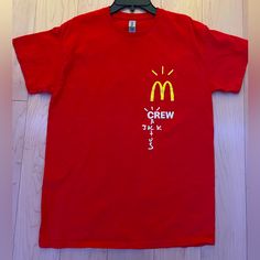 a red t - shirt with the word crew written on it and a mcdonald's logo