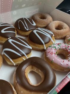 a box filled with donuts covered in frosting and sprinkles