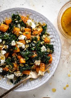 a white bowl filled with food next to a glass of beer