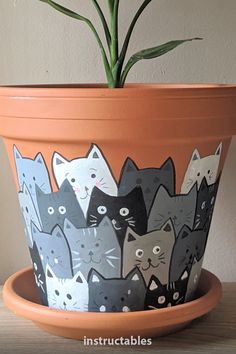 a potted plant with many cats painted on it's sides and the bottom