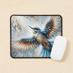 a mouse pad with a painting of a bird on it's side and a computer mouse next to it