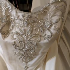 the back of a wedding dress with sequins and beaded details on it