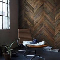 an office chair in front of a wooden wall