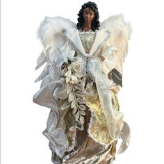 an angel figurine with white wings and flowers on it's chest, holding a tag