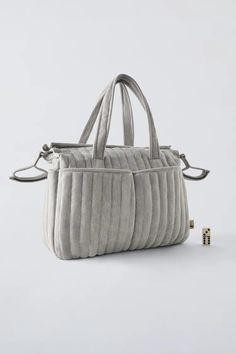 a handbag that is made out of fabric and has three compartments on the front