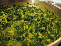 a pan filled with green vegetables on top of a stove