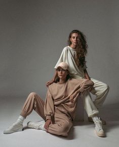 two women are sitting on the floor with their arms around each other