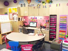 a classroom with desks, chairs and lots of books on the shelves in front of it