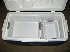 an open white cooler with two separate compartments on the inside and one empty compartment on the outside