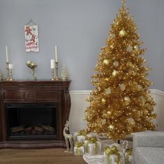 a living room with a christmas tree, fireplace and presents on the floor next to it