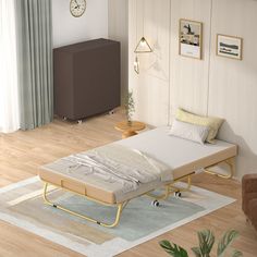 a bed sitting on top of a hard wood floor next to a wall mounted clock