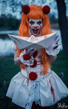 a woman with red hair and makeup is holding a paper in her hands while wearing scary makeup