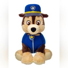 a stuffed animal with a blue shirt and hat on it's head sitting down