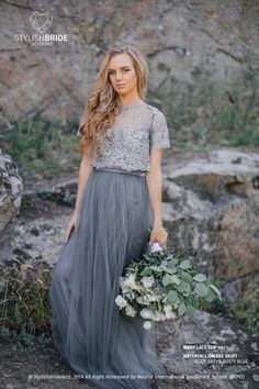 a woman in a gray dress holding a bouquet