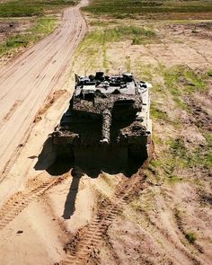 an army vehicle is parked on the side of a dirt road in the middle of nowhere