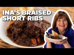 a woman holding a bowl of food with the words ina's braised short ribs