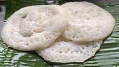 two pieces of bread sitting on top of a green leaf covered plate with water droplets