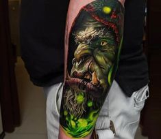 a man's arm with an image of a demon and green eyes on it