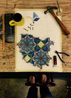 a person sitting at a table with some tools on top of it next to a piece of paper