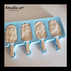 four ice cream popsicles sitting on top of a blue tray